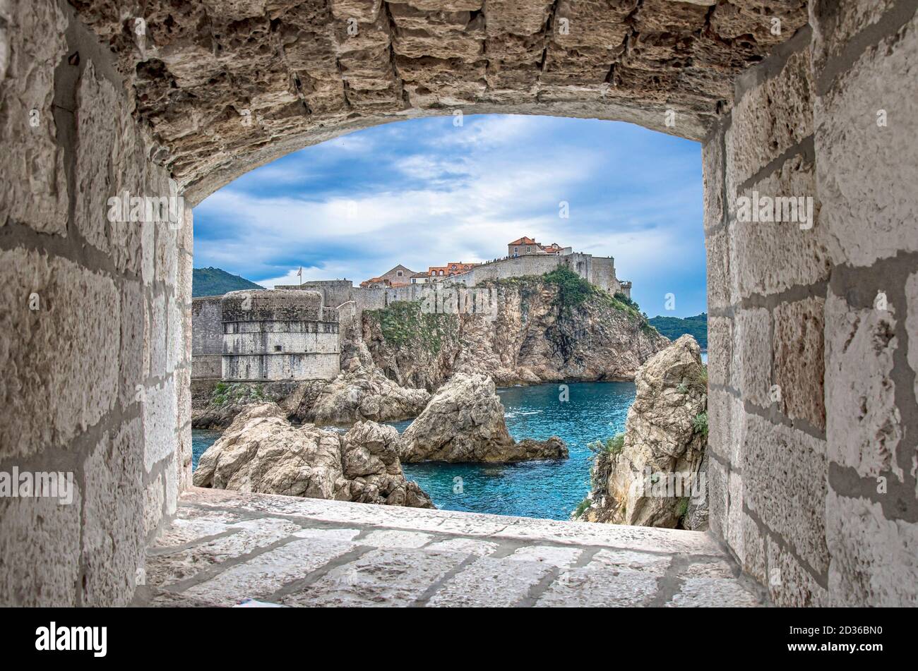 View from stone window of cliffs, sea and Dubrovnik historic wall Stock Photo
