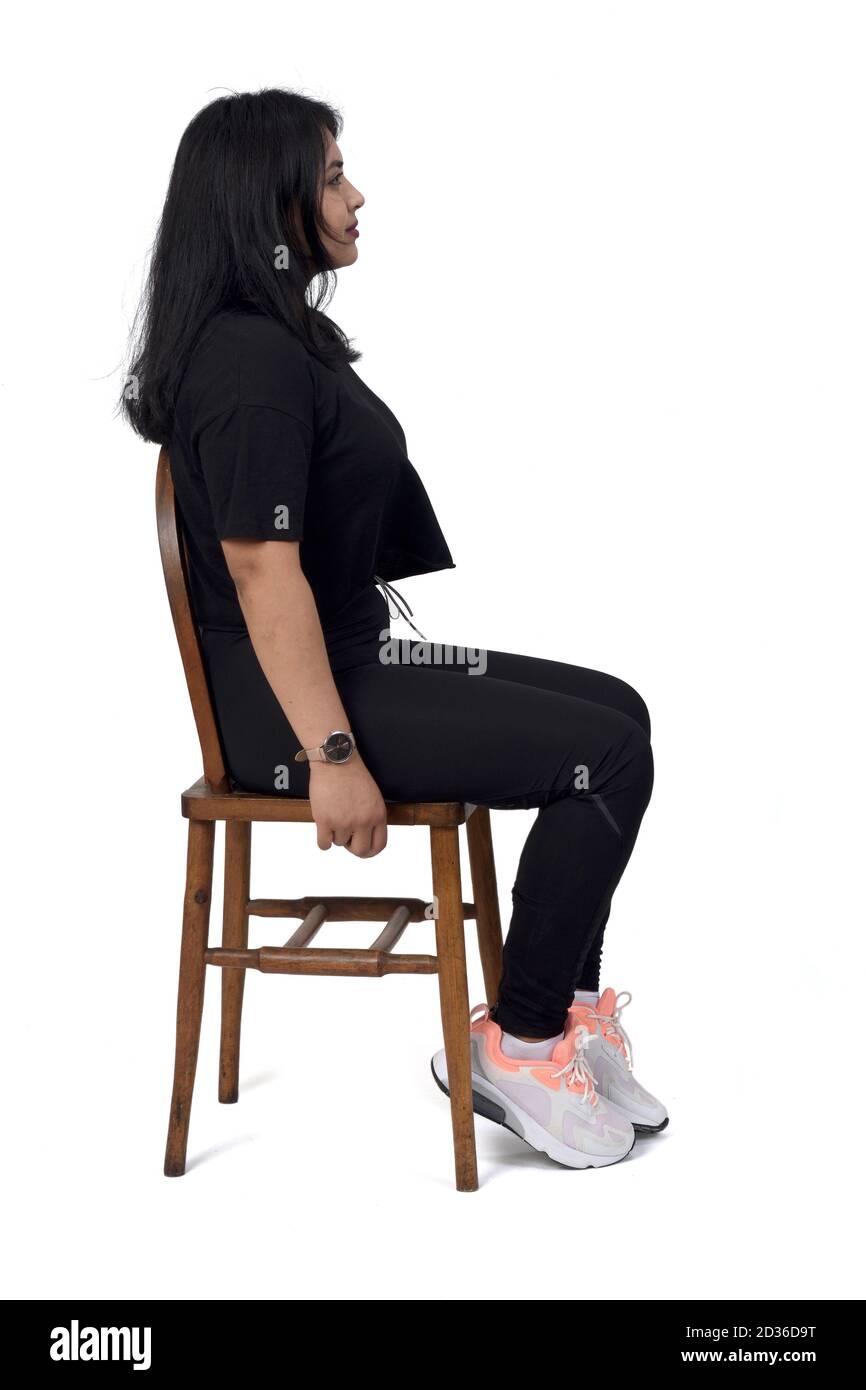 portrait of a woman sitting on a chair in white background, sideways Stock Photo