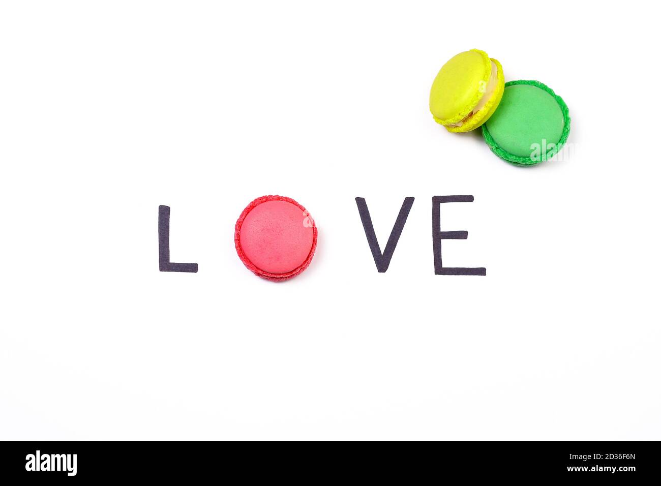 Love creative background. Hand lettering word love and sweet macaroon on white background.  Sweet love concept. Stock Photo