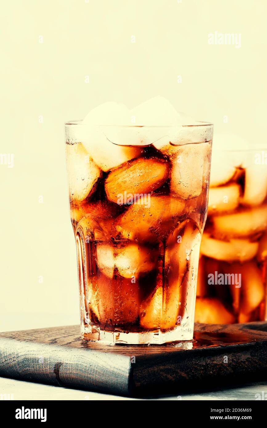 Alcoholic cocktail of rum-cola with ice, gray background, selective focus Stock Photo