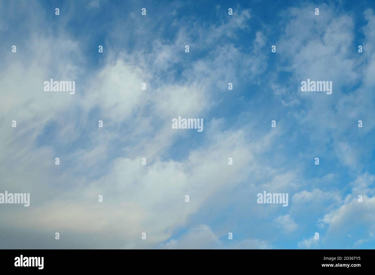 Cirrus clouds on blue sunny spring sky, nature background without focus Stock Photo