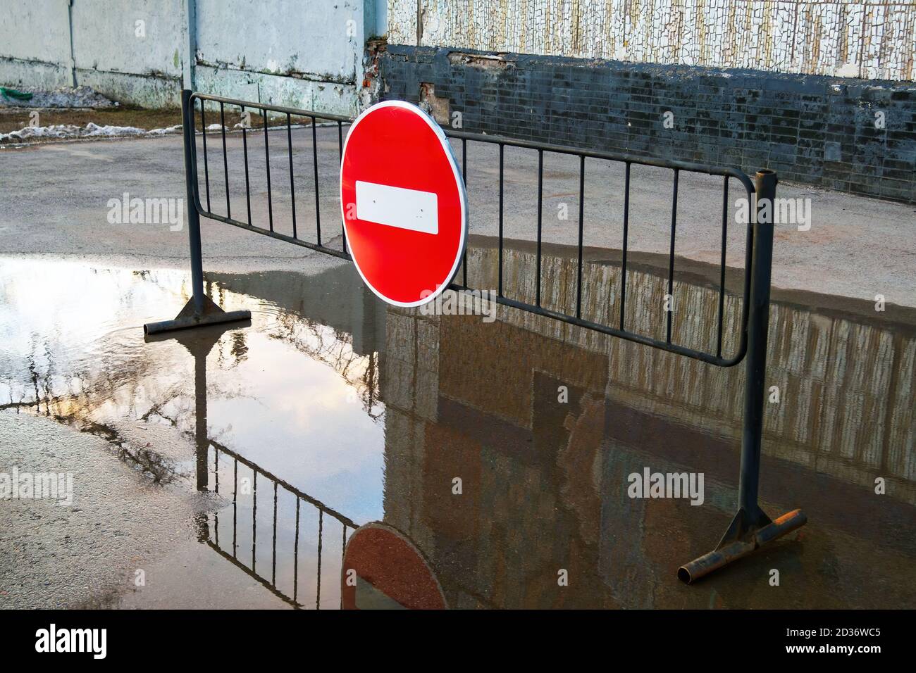 Road sign No entry for vehicular traffic on metal stand in puddle near building Stock Photo