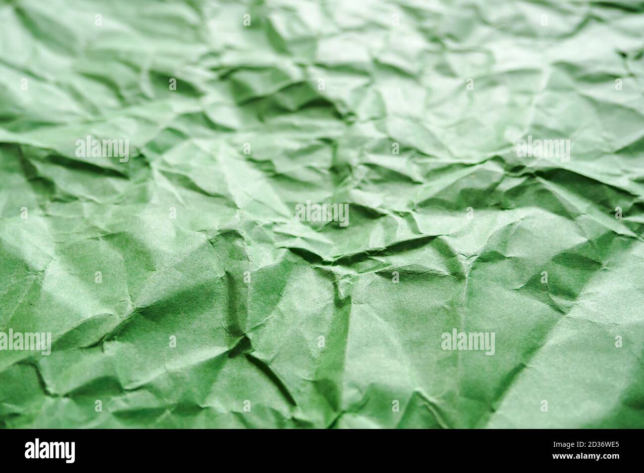 Crumpled green paper, abstract background, selective focus Stock Photo