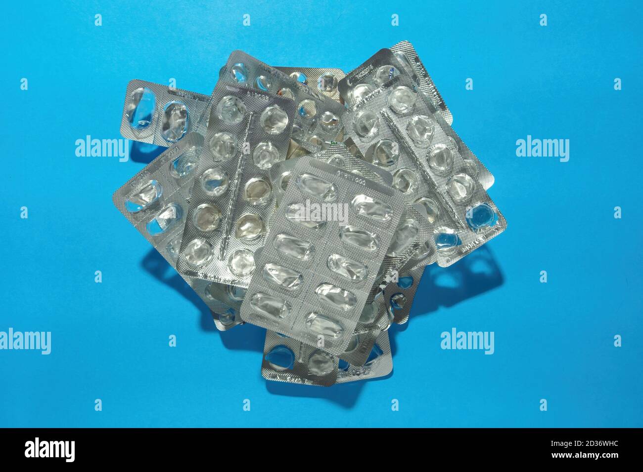 Pile blank blister packs without pills on blue background. Medical and healthcare concept. Top view Stock Photo