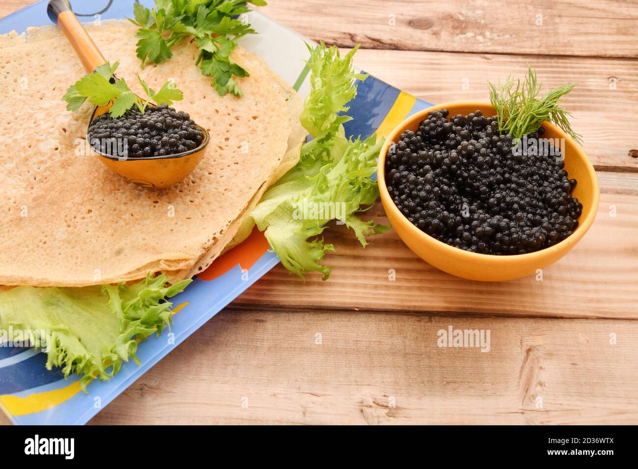 Pancakes with black caviar and fresh herbs Stock Photo