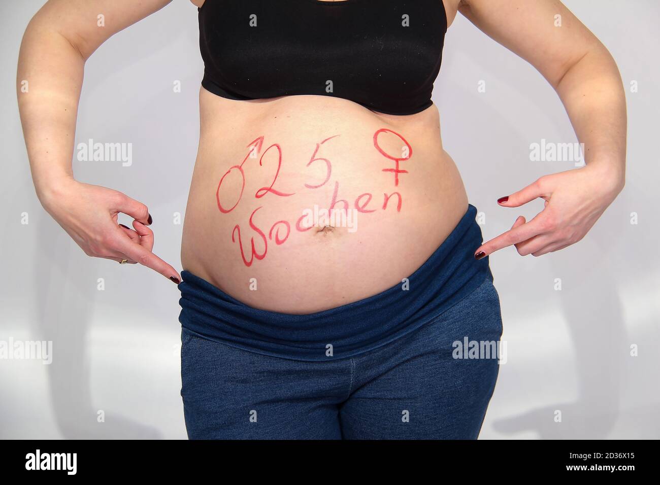 Closeup Shot Of A Pregnant Woman Pointing At Her Belly With 25 Weeks Written On It In German Stock Photo Alamy