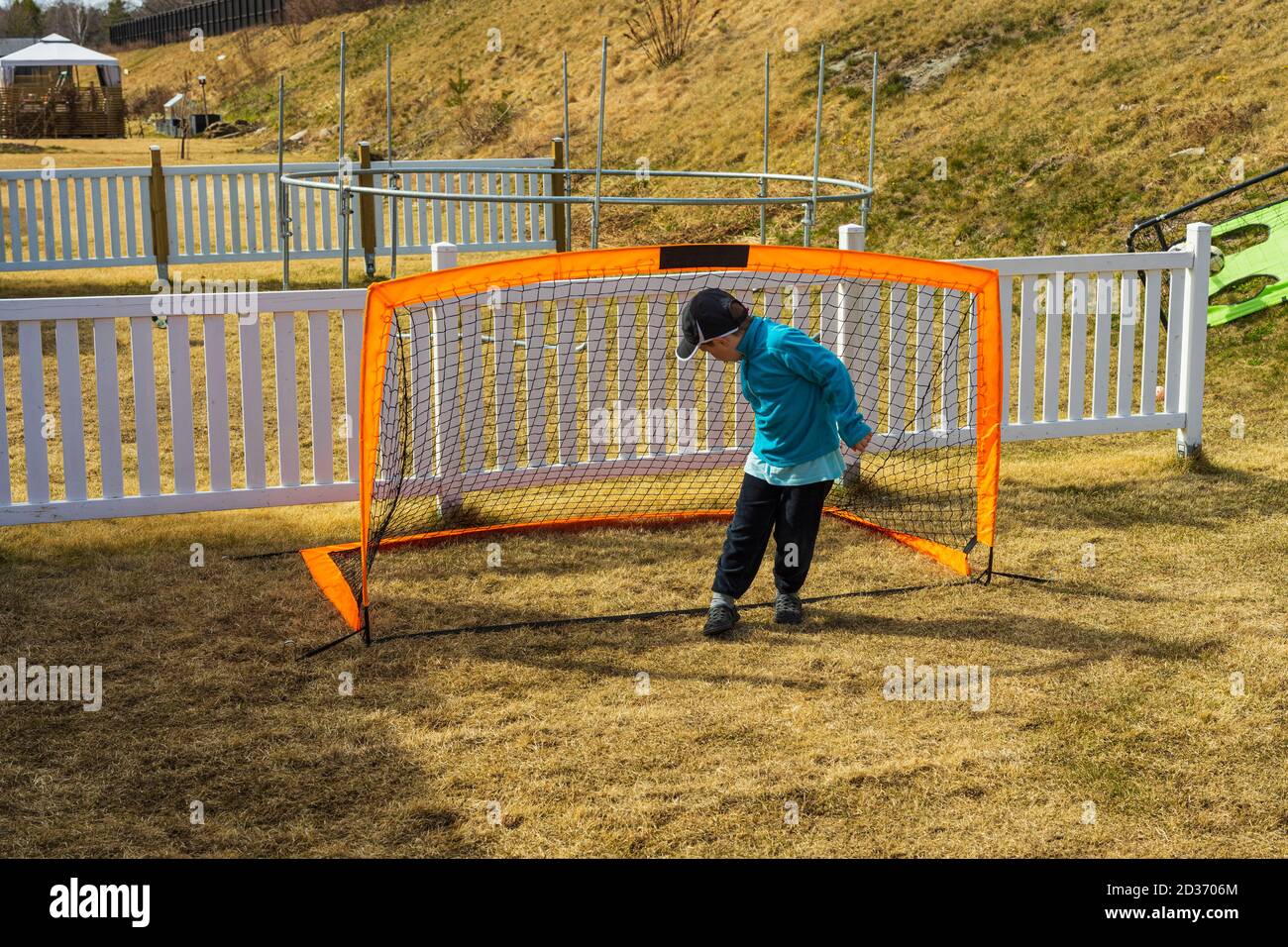 Stay at home. COVID 19. Close up view of boy playing football on backyard.  Outdoor games concept. Stock Photo