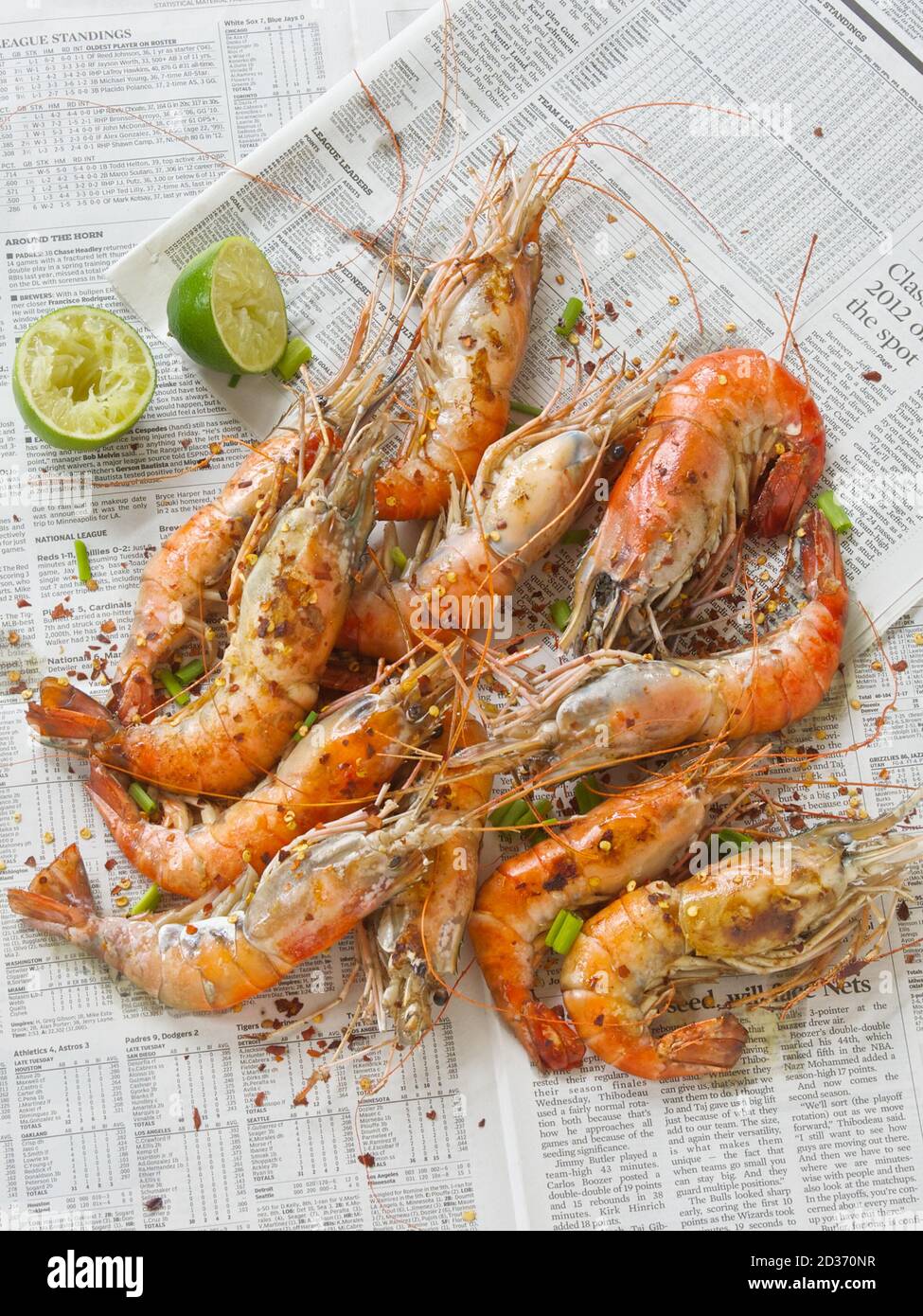Cooked prawns spread out on newsprint for seafood boil. Stock Photo