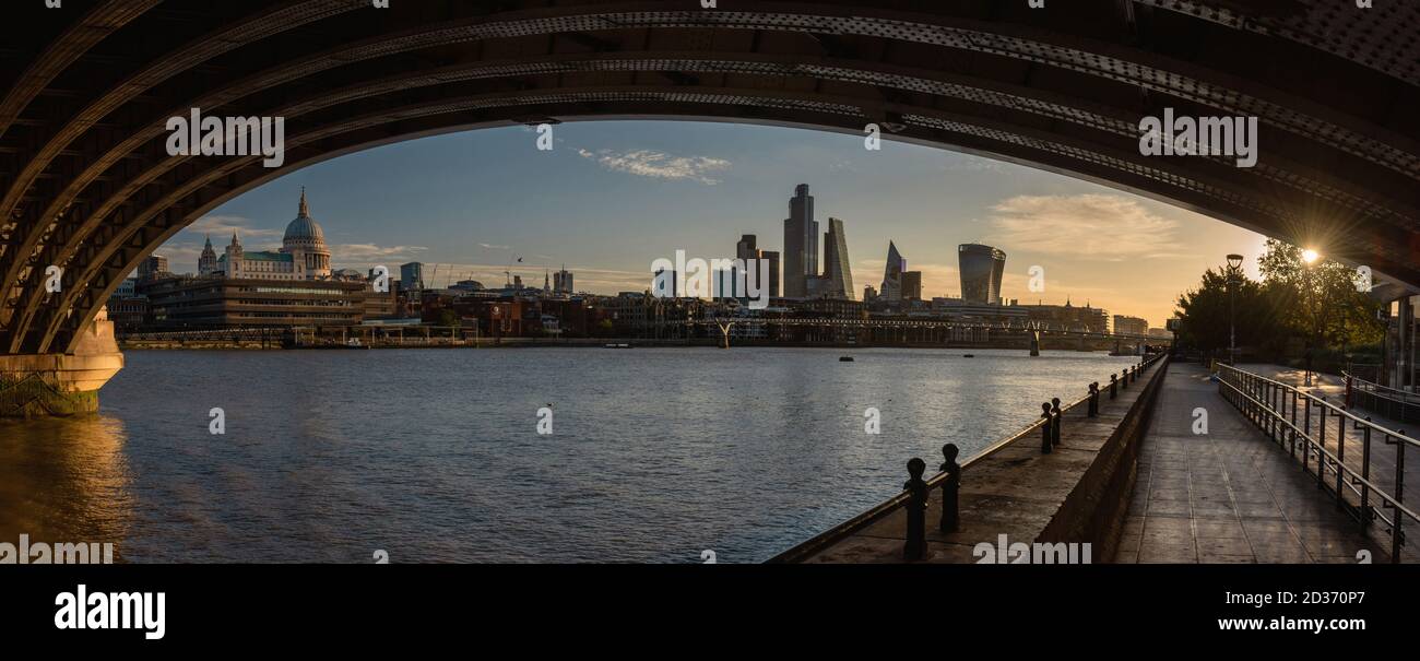 London's city skyline at sunrise. Panoramic view from under the Blackfriars Bridge, England Stock Photo