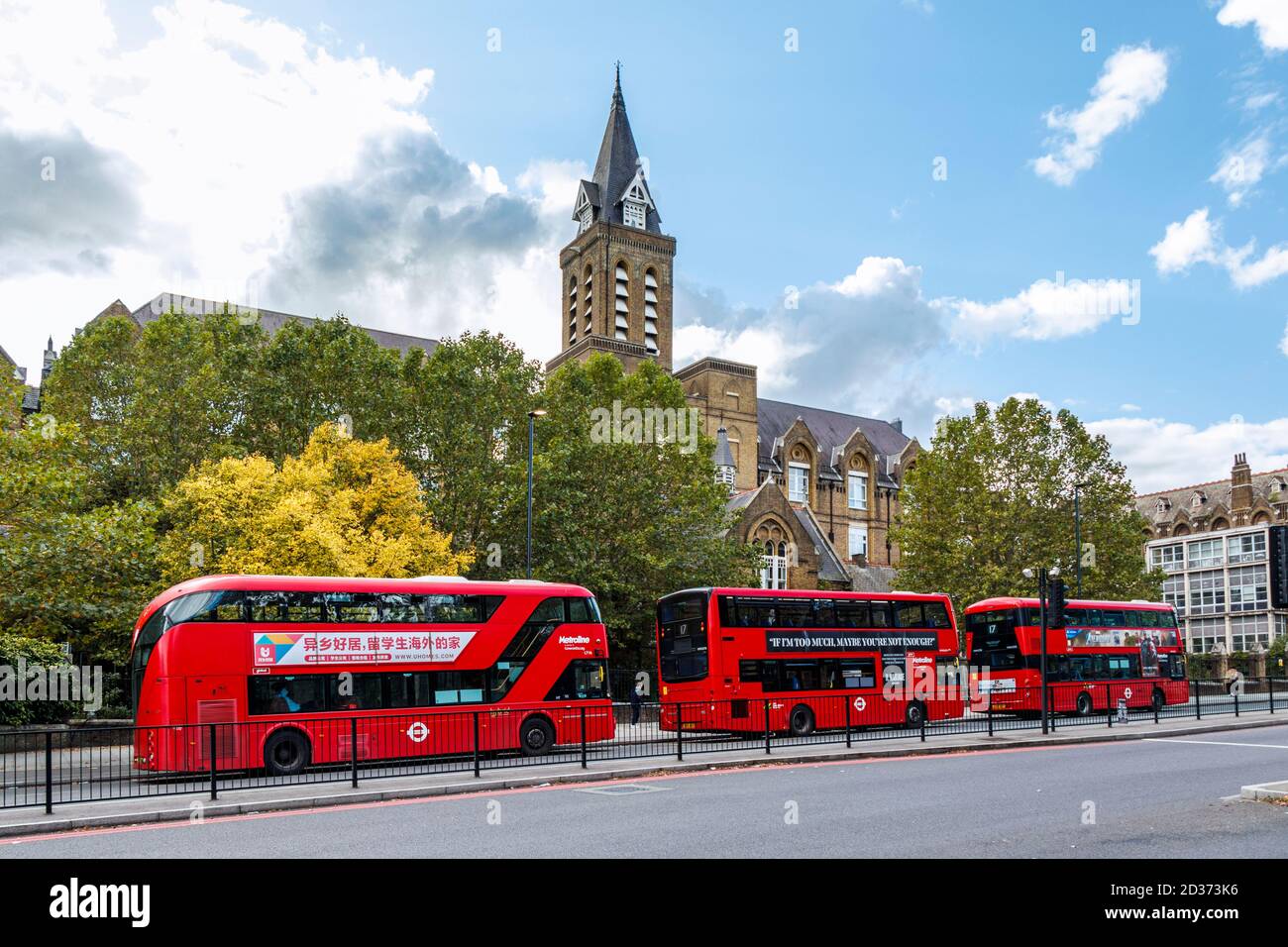 A bus stand of three red buses on Archway Road, the building known as the 'Holborn Infirmary' behind, London, UK Stock Photo
