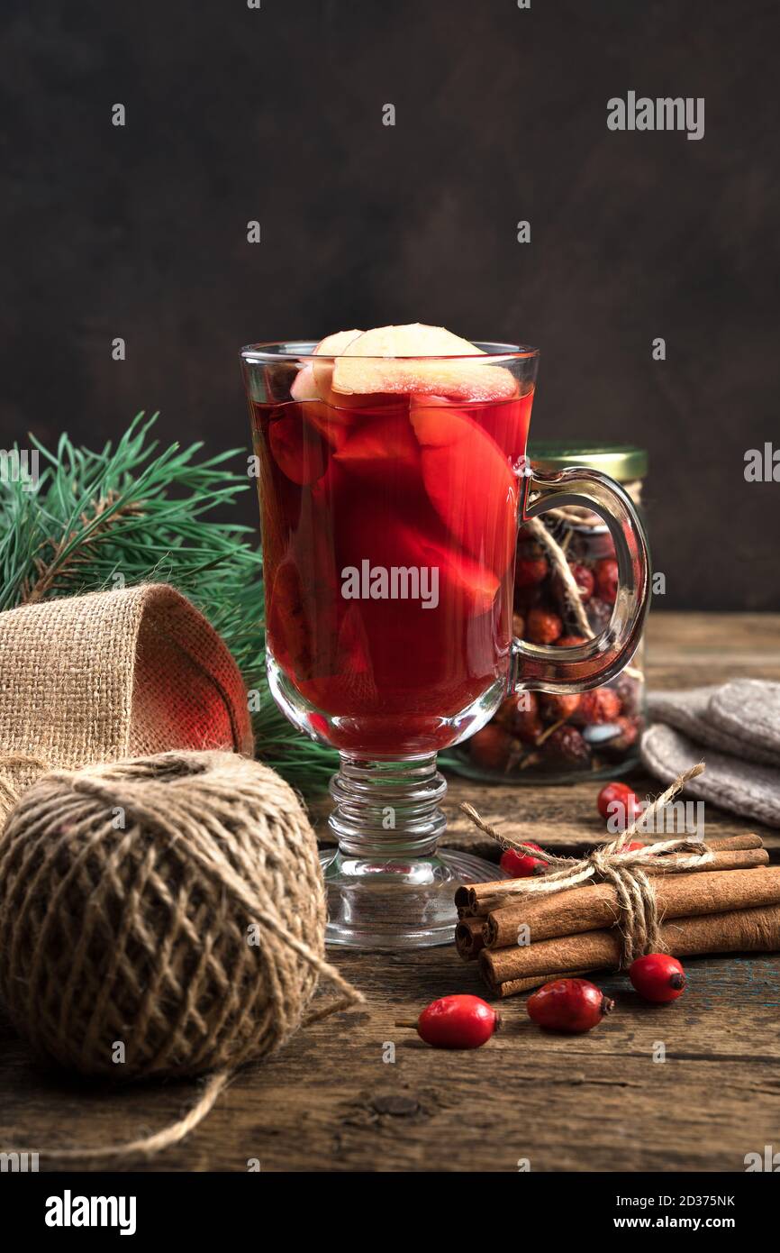 Happy New year and merry Christmas, a warm festive drink with fruit, berries and cinnamon on a wooden background. Stock Photo