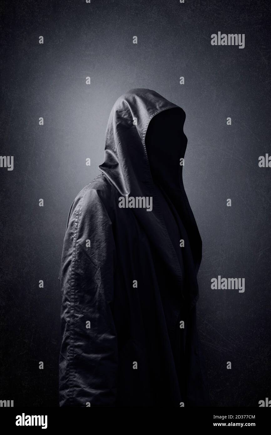 Scary figure in hooded cloak in the dark Stock Photo - Alamy