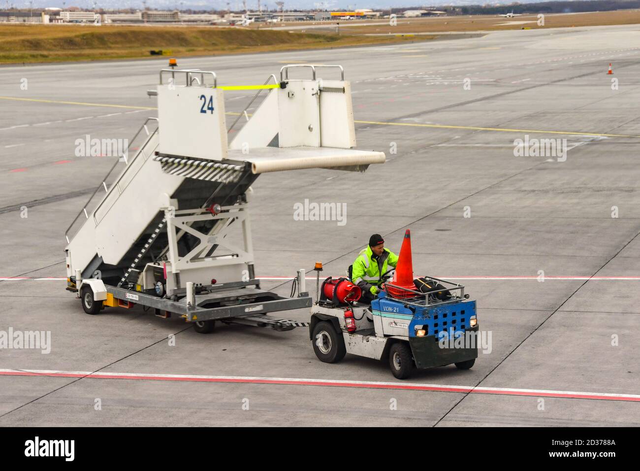 BUDAPEST, HUNGARY - MARCH 2019: Airport worker towing a set of passenger steps to an aircraft after its arrival in Budapest airport. Stock Photo