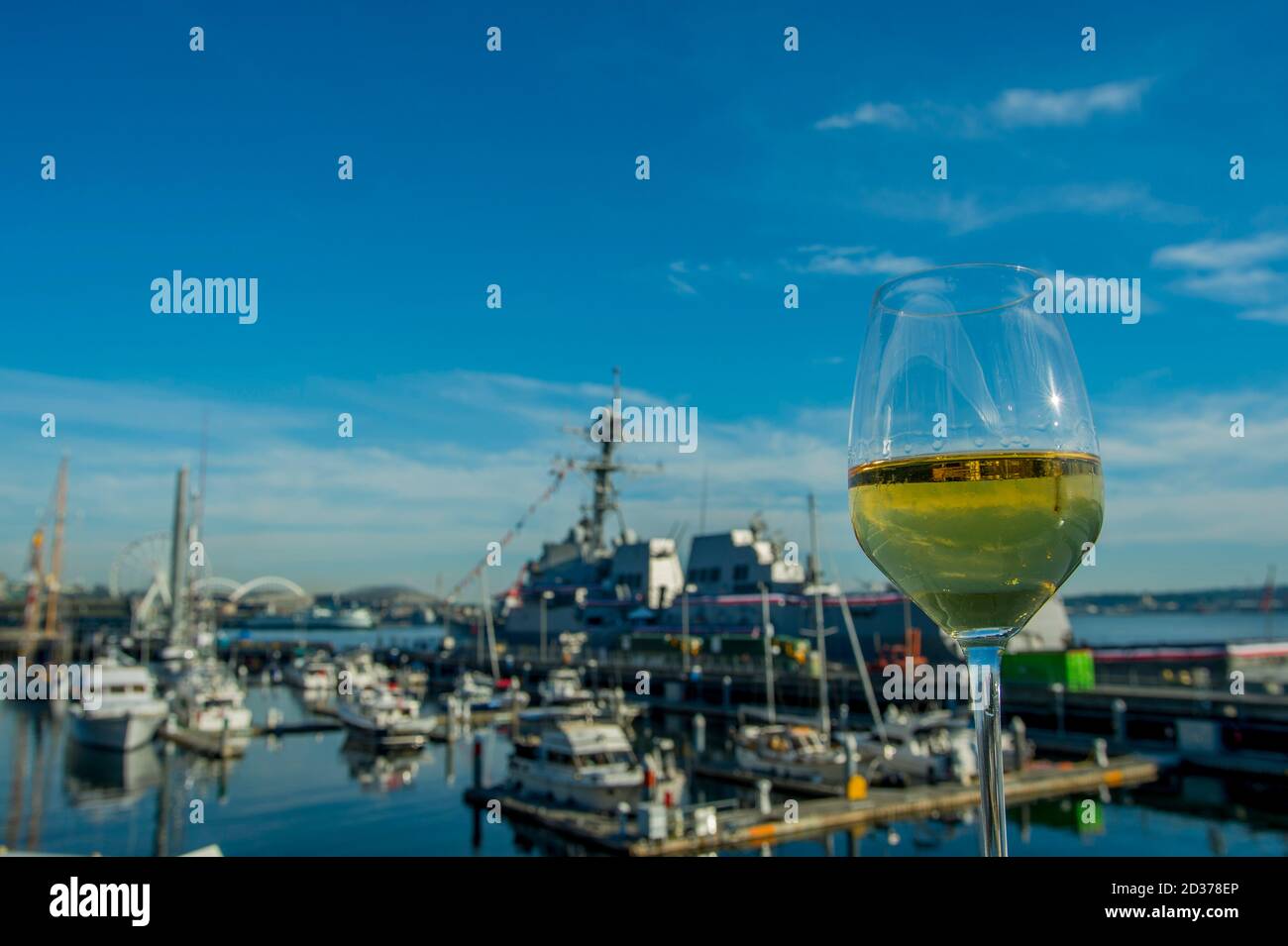 Glass of Chardonnay wine with Seattle Waterfront in background from Pier 66, Anthony's Restaurant, Washington State, USA. Stock Photo