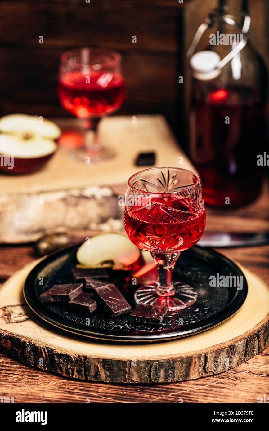 Homemade red currant nalivka and chocolate with apple Stock Photo