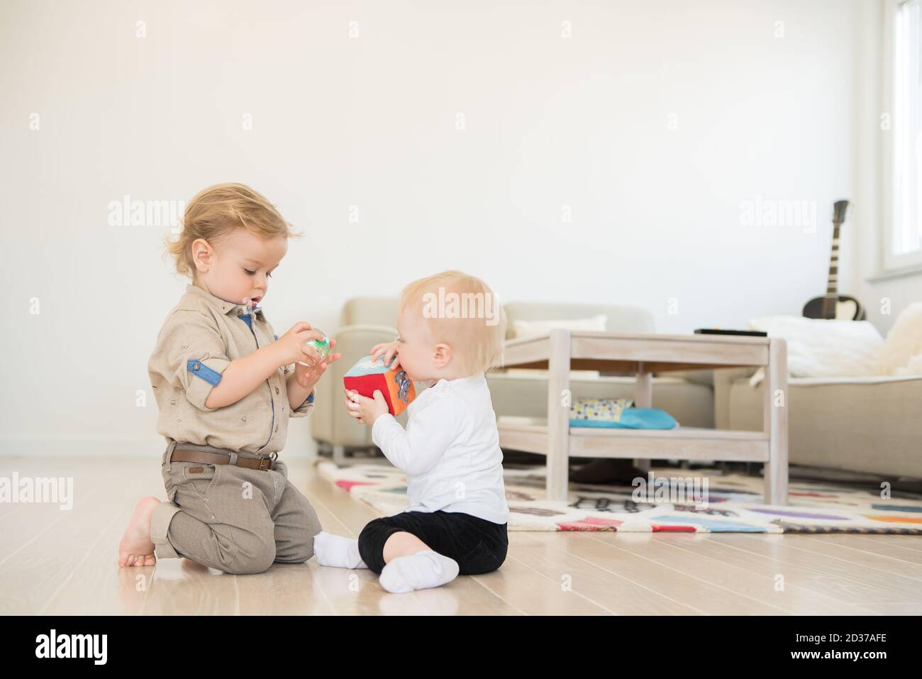 Cute little girl and boy playing with toys at home Stock Photo - Alamy