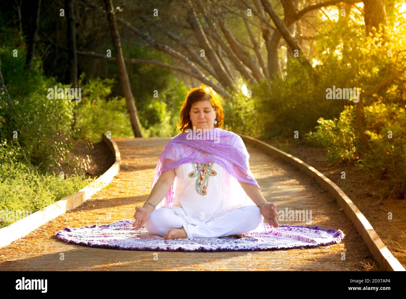 Woman meditating sitting in the lotus position with her hands on her ...