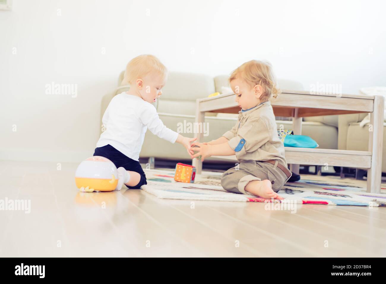 Cute little girl and boy playing with toys at home Stock Photo - Alamy