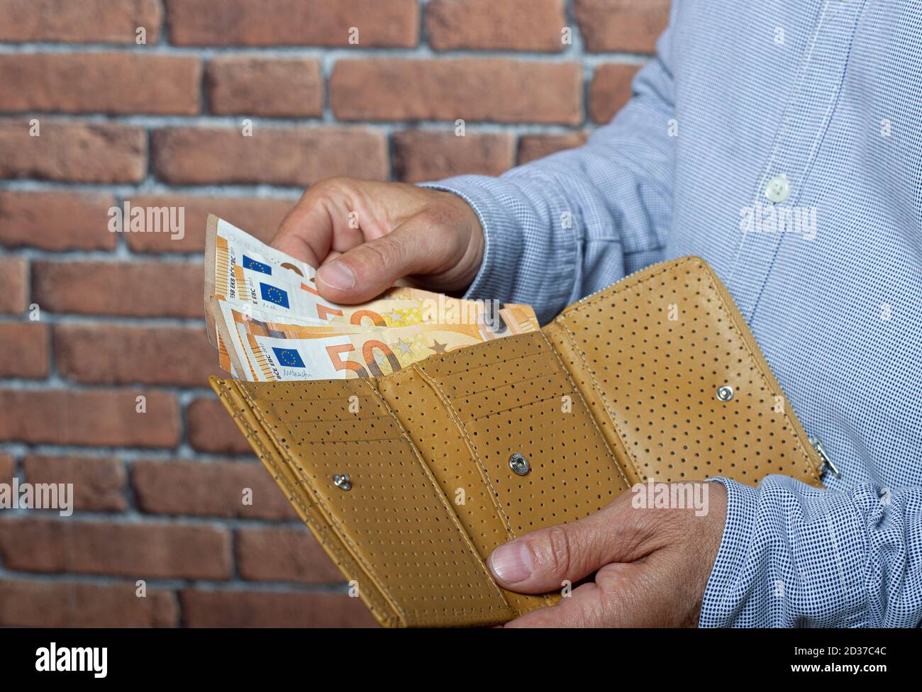 Man taking euro money out of his pocket wallet. Stock Photo