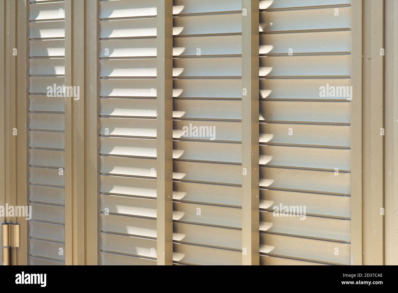 Closed gold-colored metallic shutters, metal blinds with hinge Stock Photo