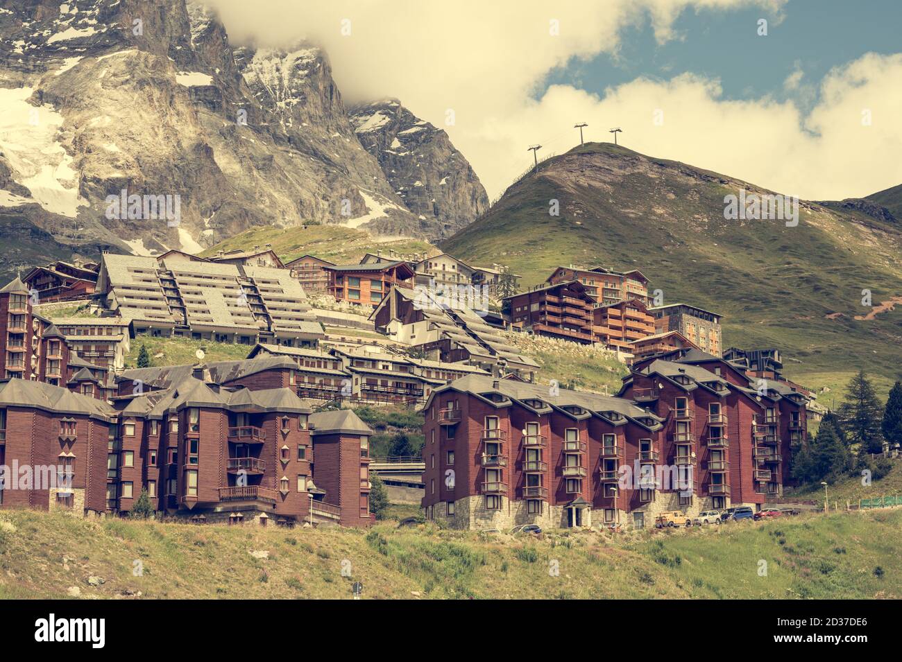 View of Alpine themed apartment mountain resort under high peaks Stock Photo ...