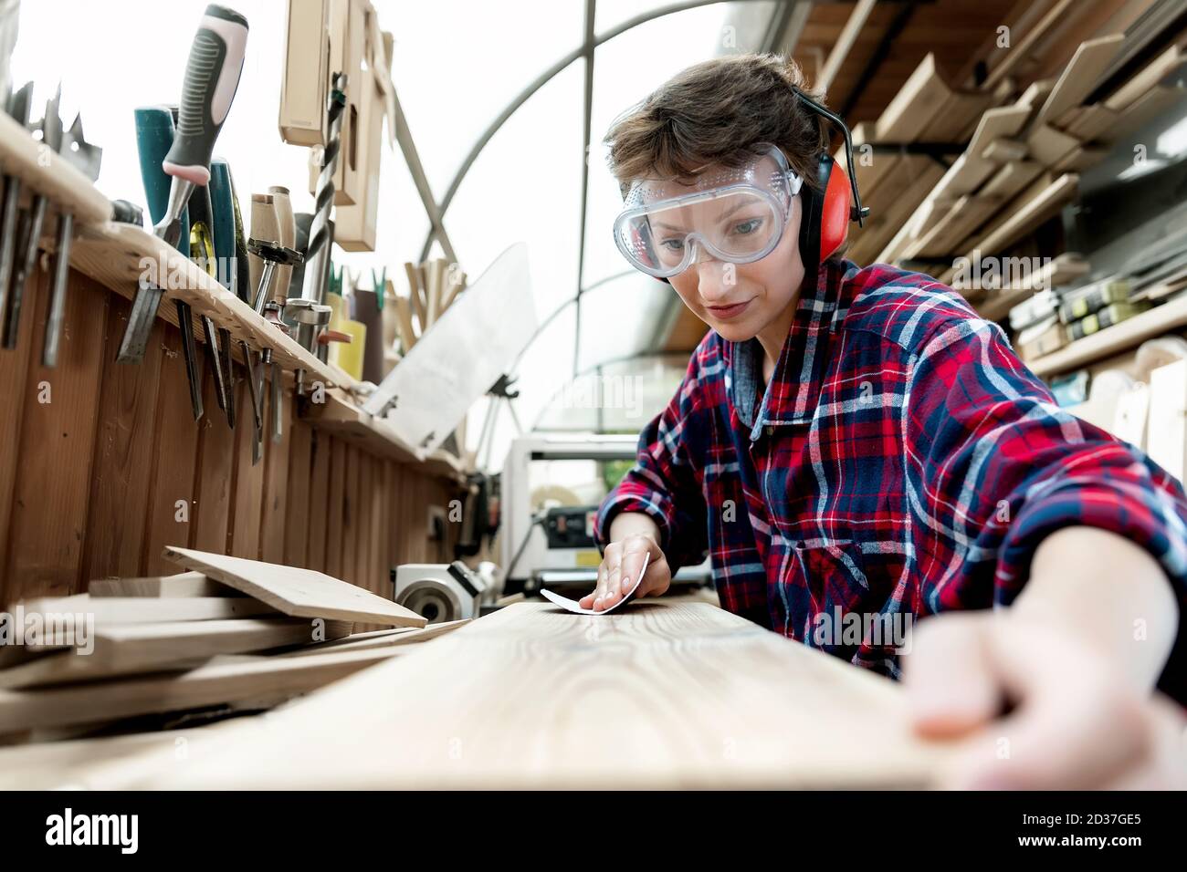 Young attractive 3040 professional female carpenter looking grinding