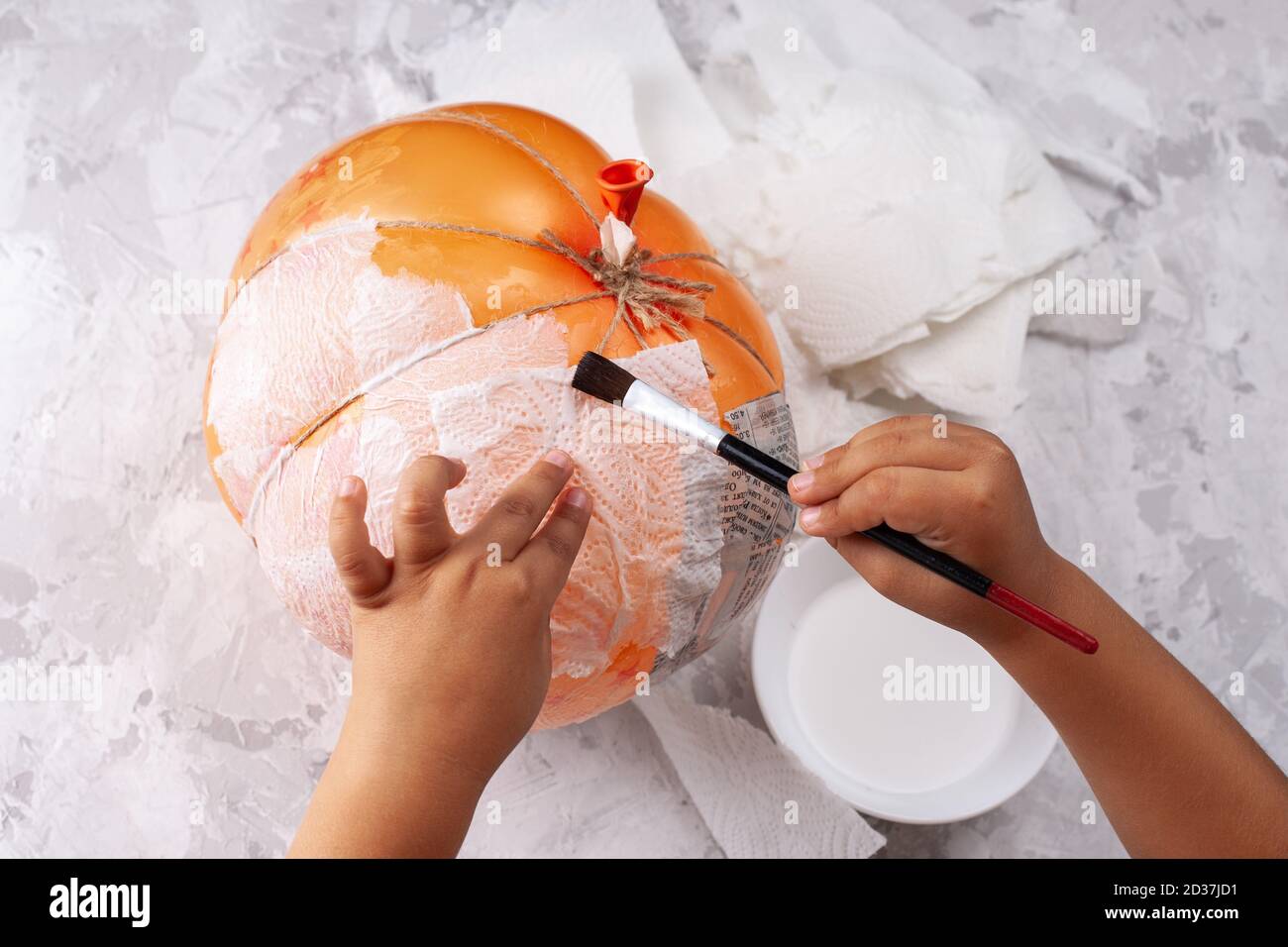 baby's hands makes a papiermache pumpkin from a balloon, DIY for
