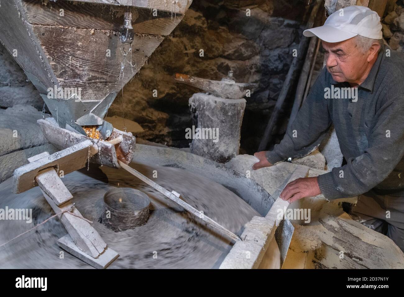 Old mill for grinding grain up close. The miller grinds grain Stock