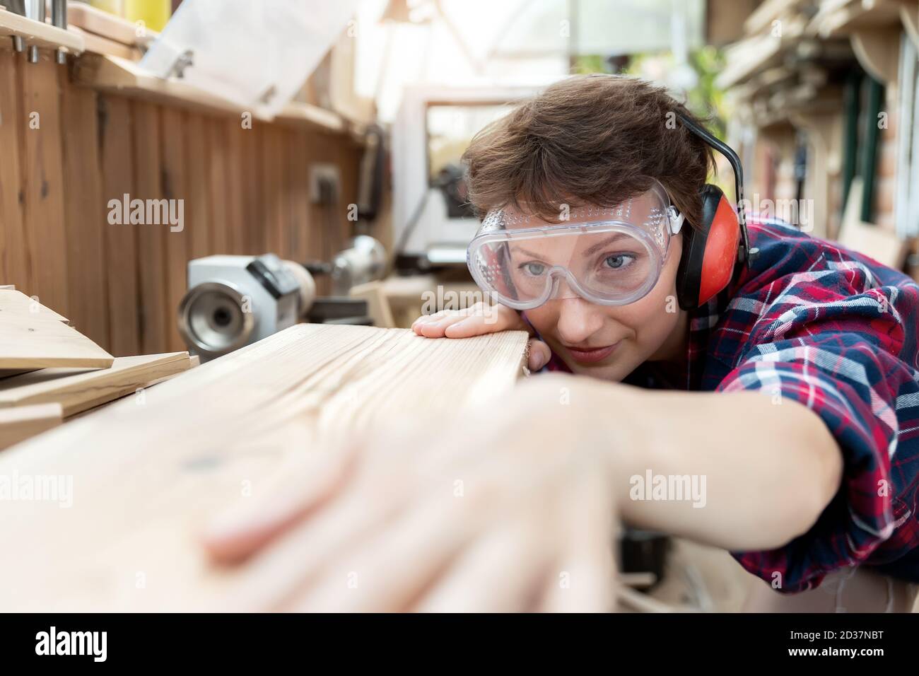 Young attractive 3040 professional female carpenter looking grinding