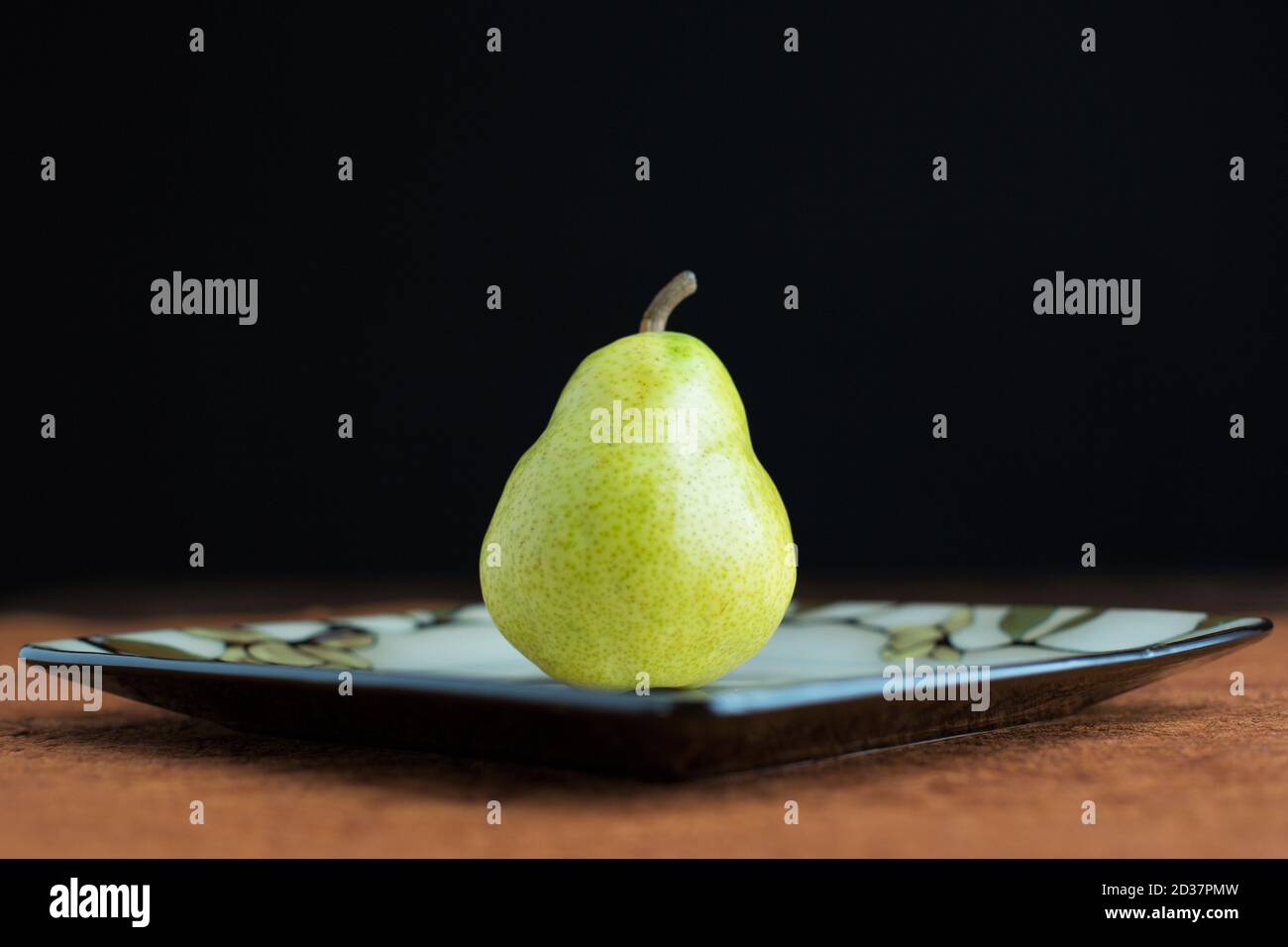 A single bartlett pear on a plate. Stock Photo
