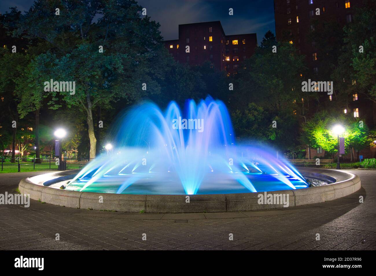 Blue, round colored water fountain at night Stock Photo - Alamy