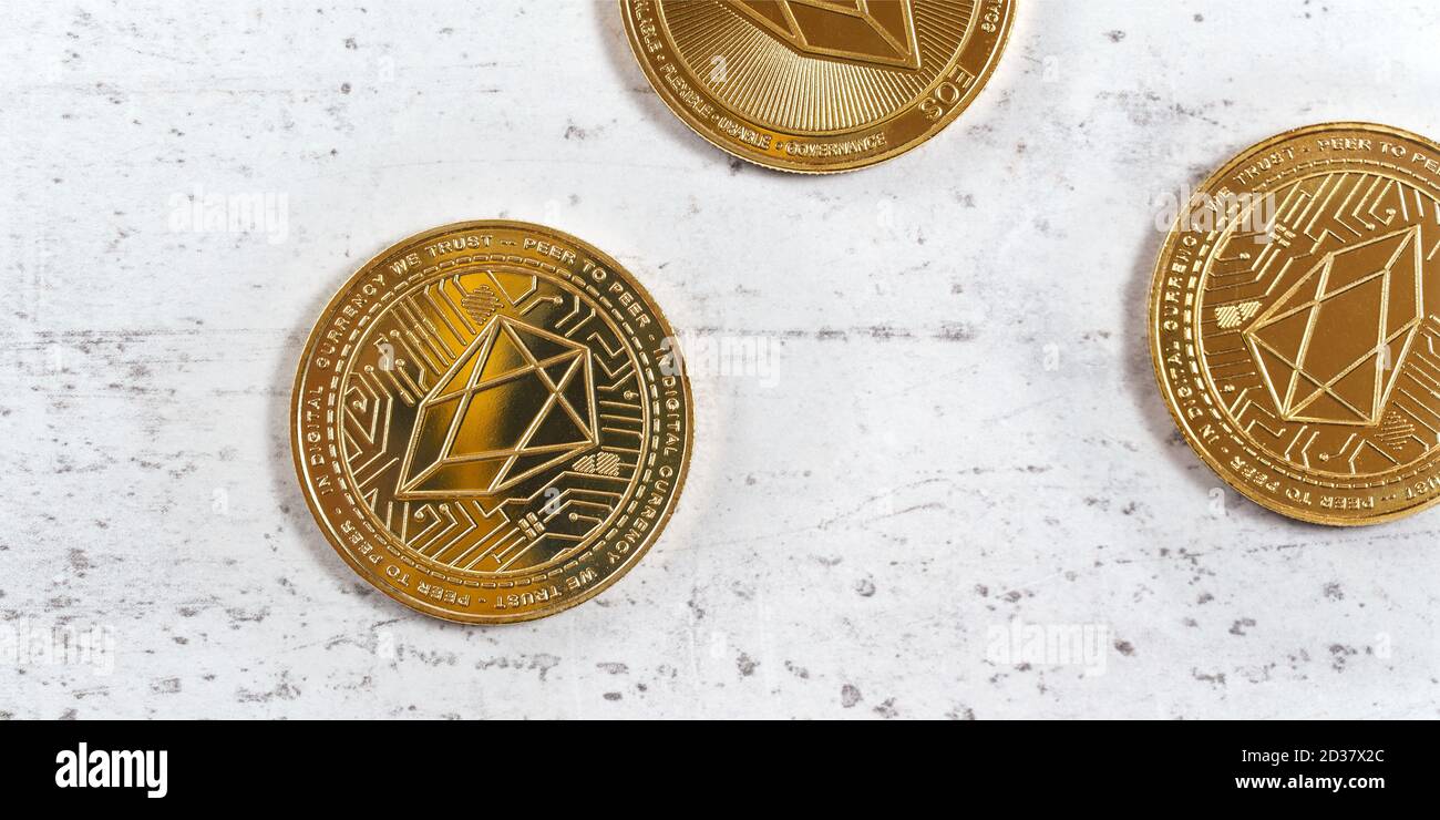 Top down view, golden commemorative EOS - EOSIO  cryptocurrency - coins on white stone board Stock Photo