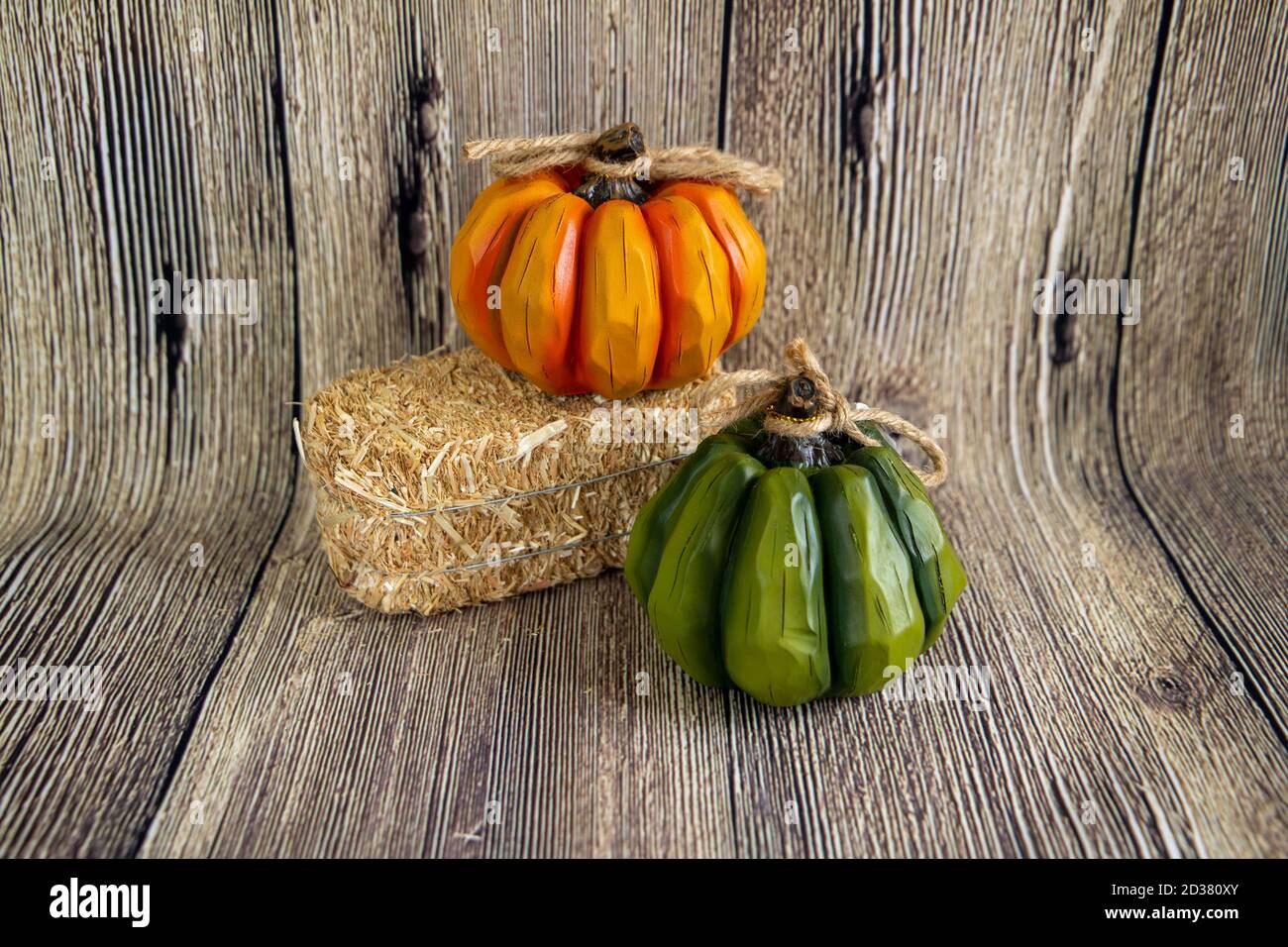 Decorative green and orange pumpkin and a hey stack isolated on the wood background. Holidays Stock Photo