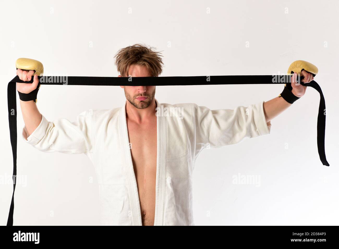 Man with hidden sight holds black belt on white background. Mixed