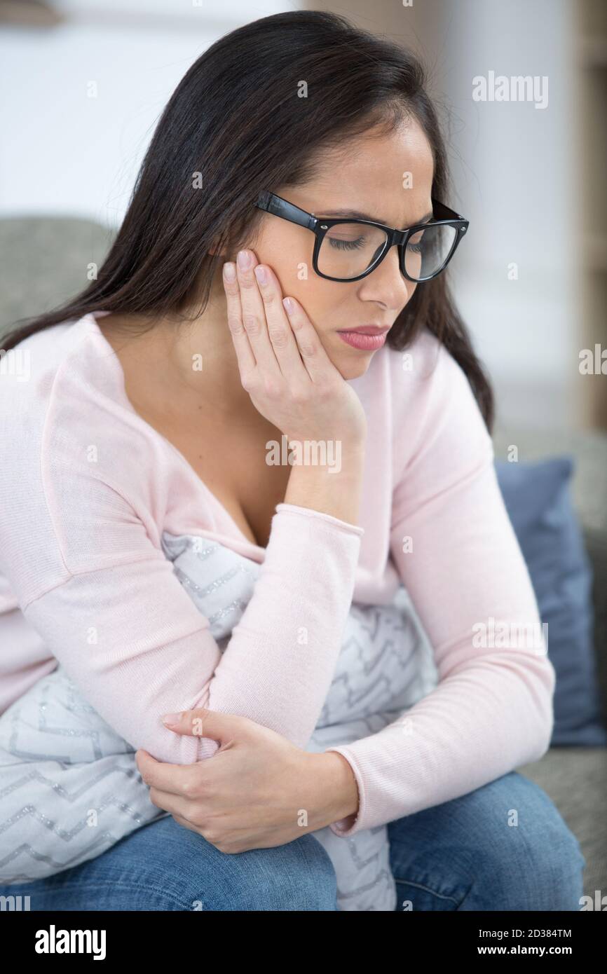 sad woman looking away at home in the living room Stock Photo - Alamy