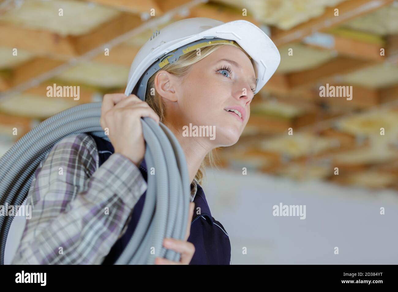 female electrician installing ventilation in ceiling Stock Photo