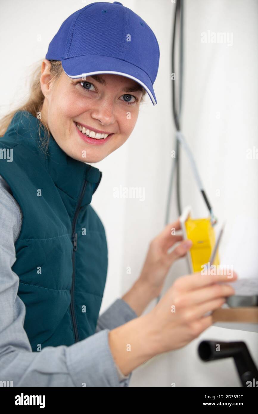 female electrician at work installing switch Stock Photo