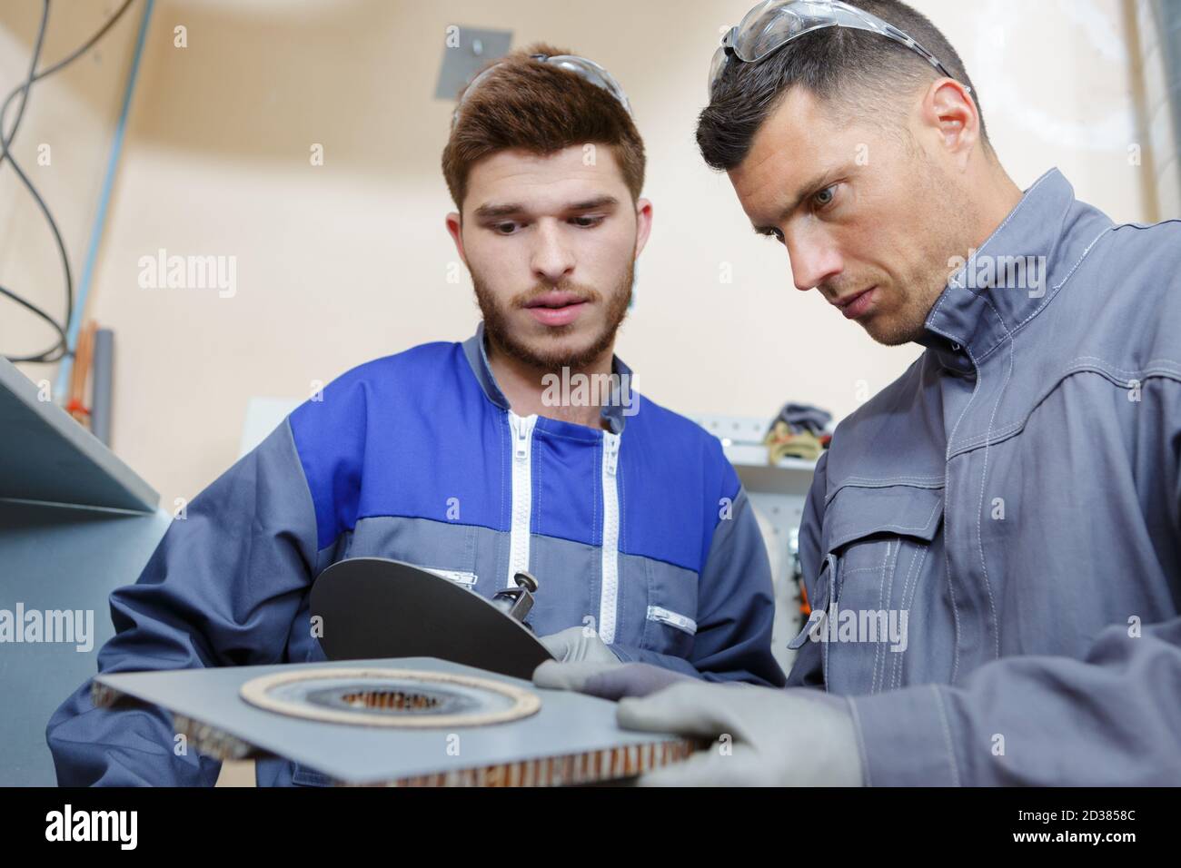 engineer and apprentice examining mechanical component Stock Photo Alamy