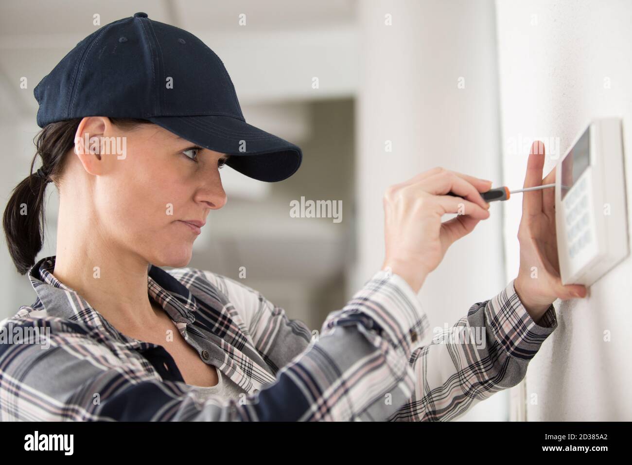 female technician installing a house thermostat Stock Photo Alamy