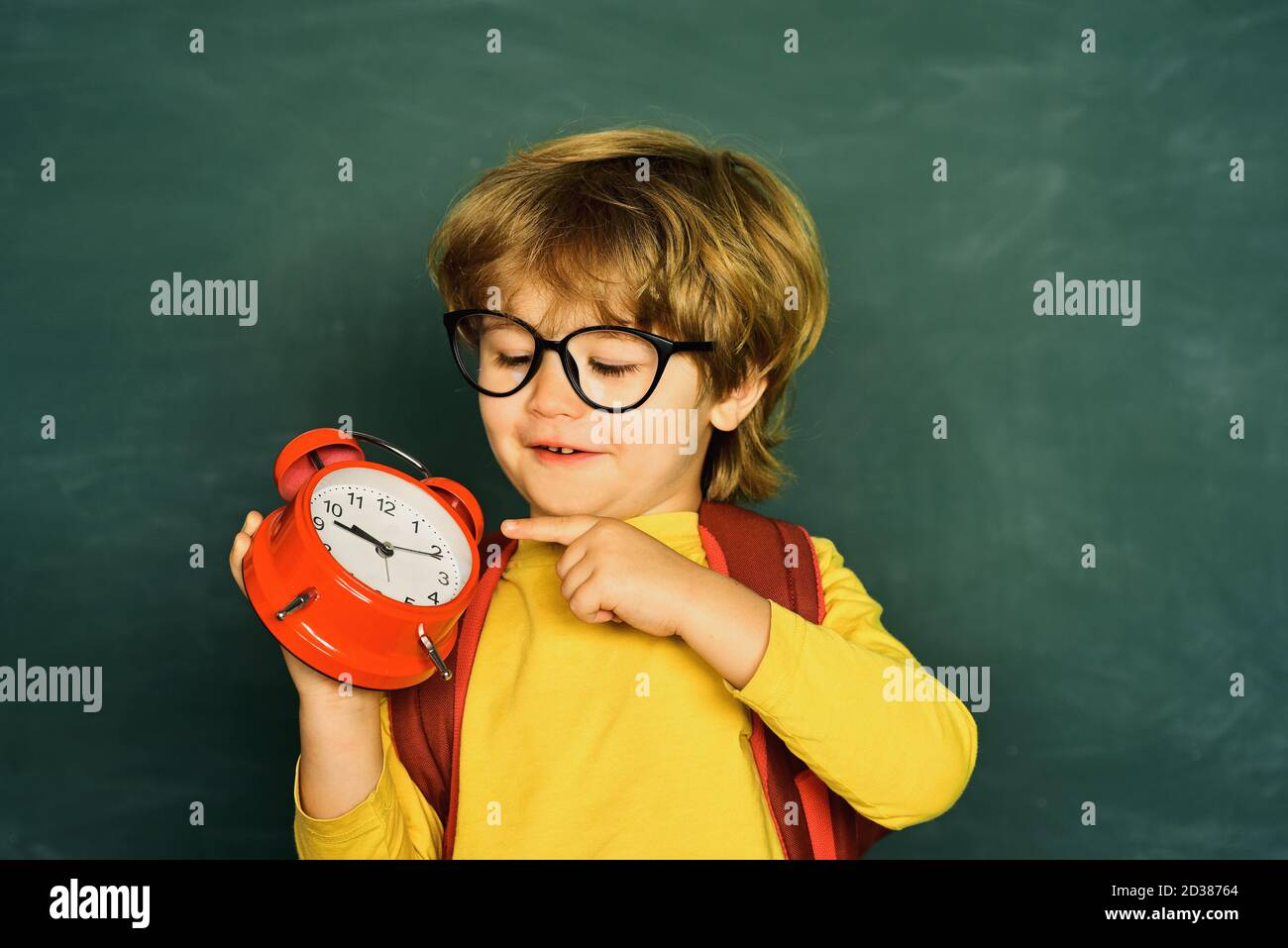 Back to school. Alarm clock anxiety. Late. Kid boy holding clock alarm