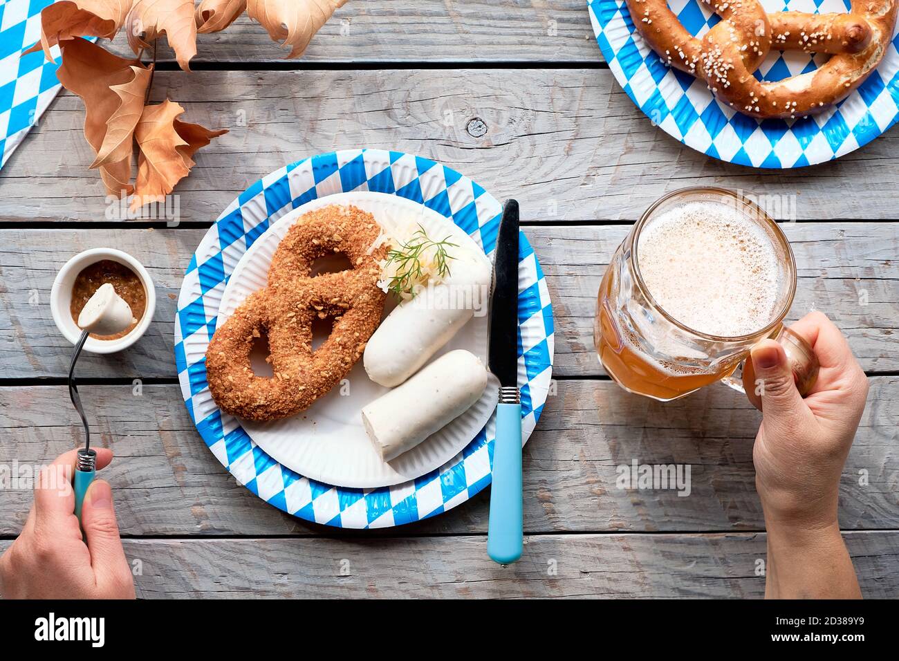 Celebrating Oktoberfest alone. Traditional food and beer, weisswurst sausage and pretzels. Stock Photo