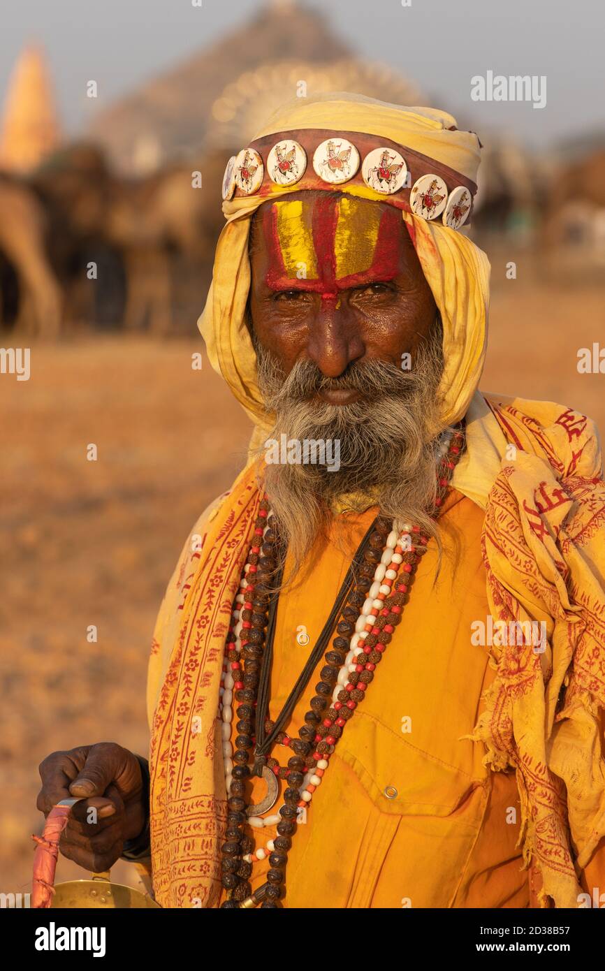 A portrait of a holy person with color on his fore head and beard wearing saffron colored clothes at Pushkar, Rajasthan, India on 19 November 2018 Stock Photo