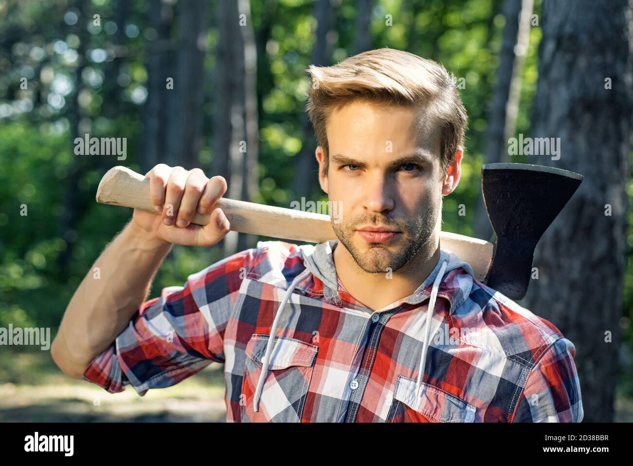 Lumberjack on serious face carries axe on shoulder Stock Photo Alamy