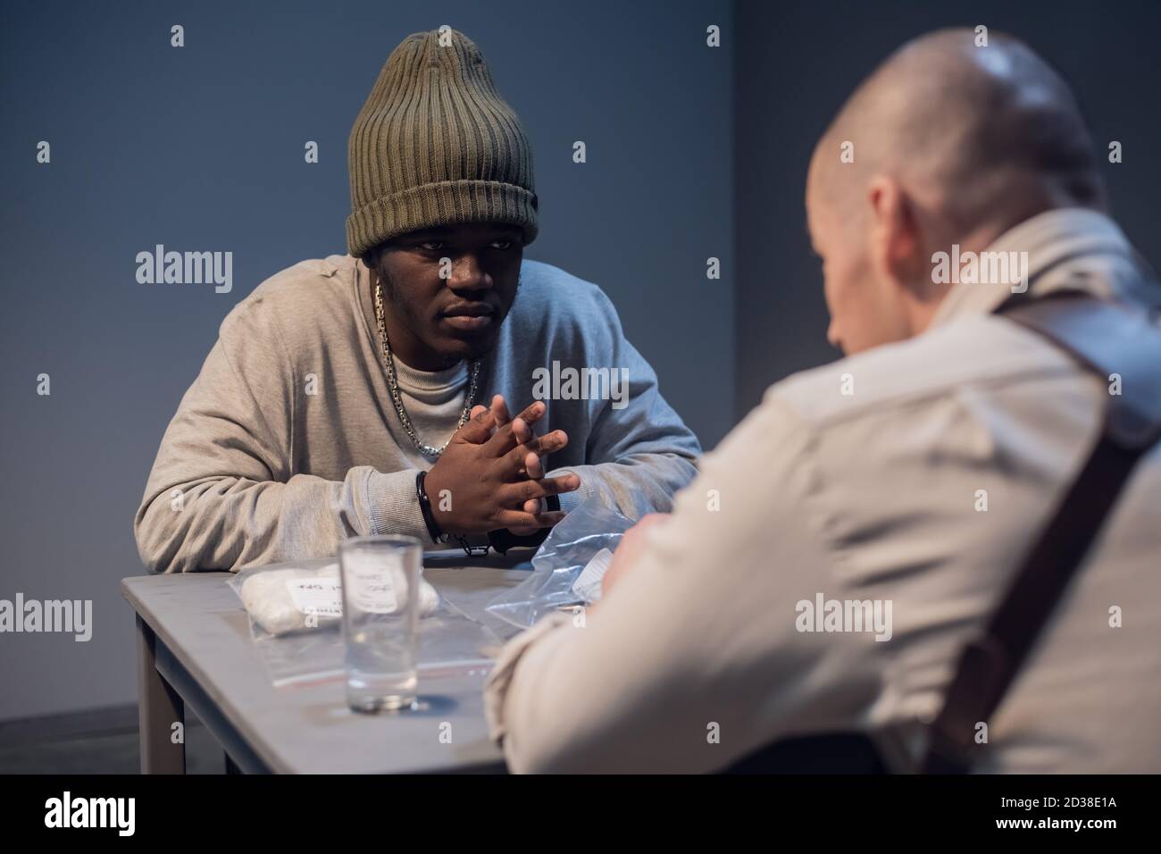A young black criminal realizes what was done during the interrogation at the police station. Stock Photo