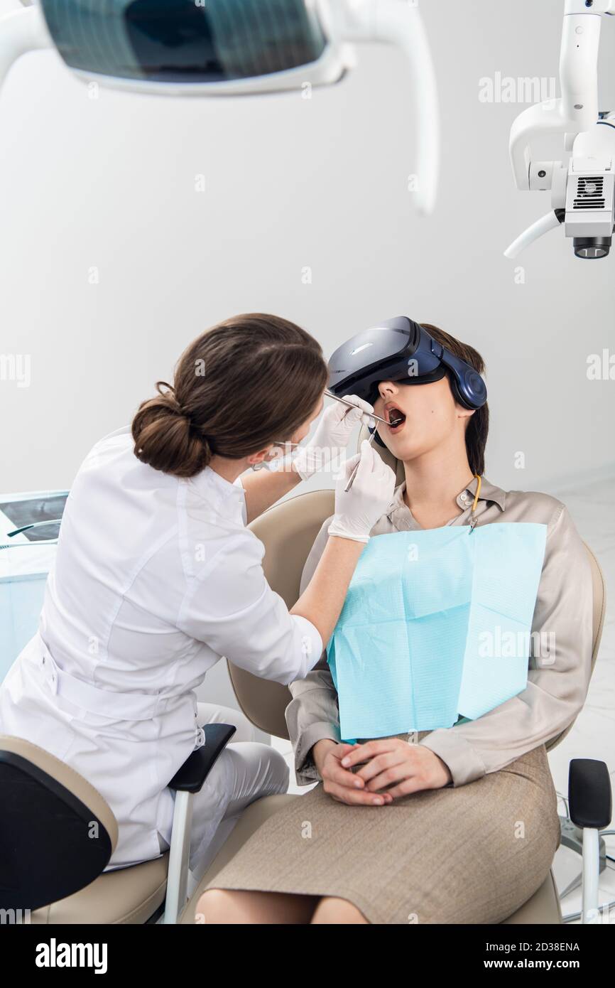 The Dentist Is Doing Her Job While The Patient Is Lying With Her Mouth Wide Open Wearing Vr 6144