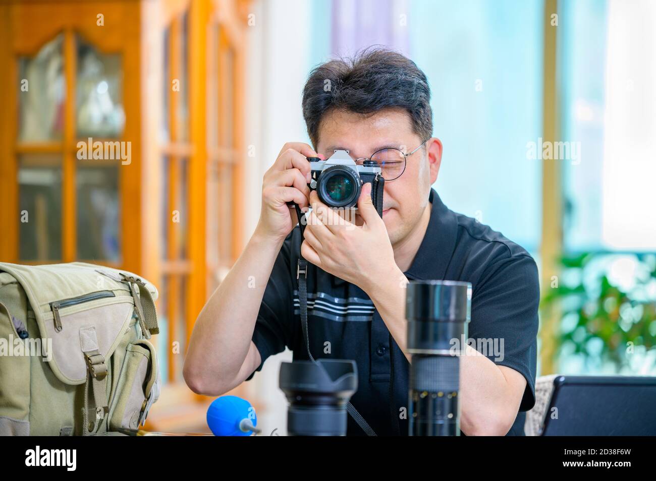 A middle-aged Asian man whose hobby is 35mm/135mm film SLR camera. Stock Photo