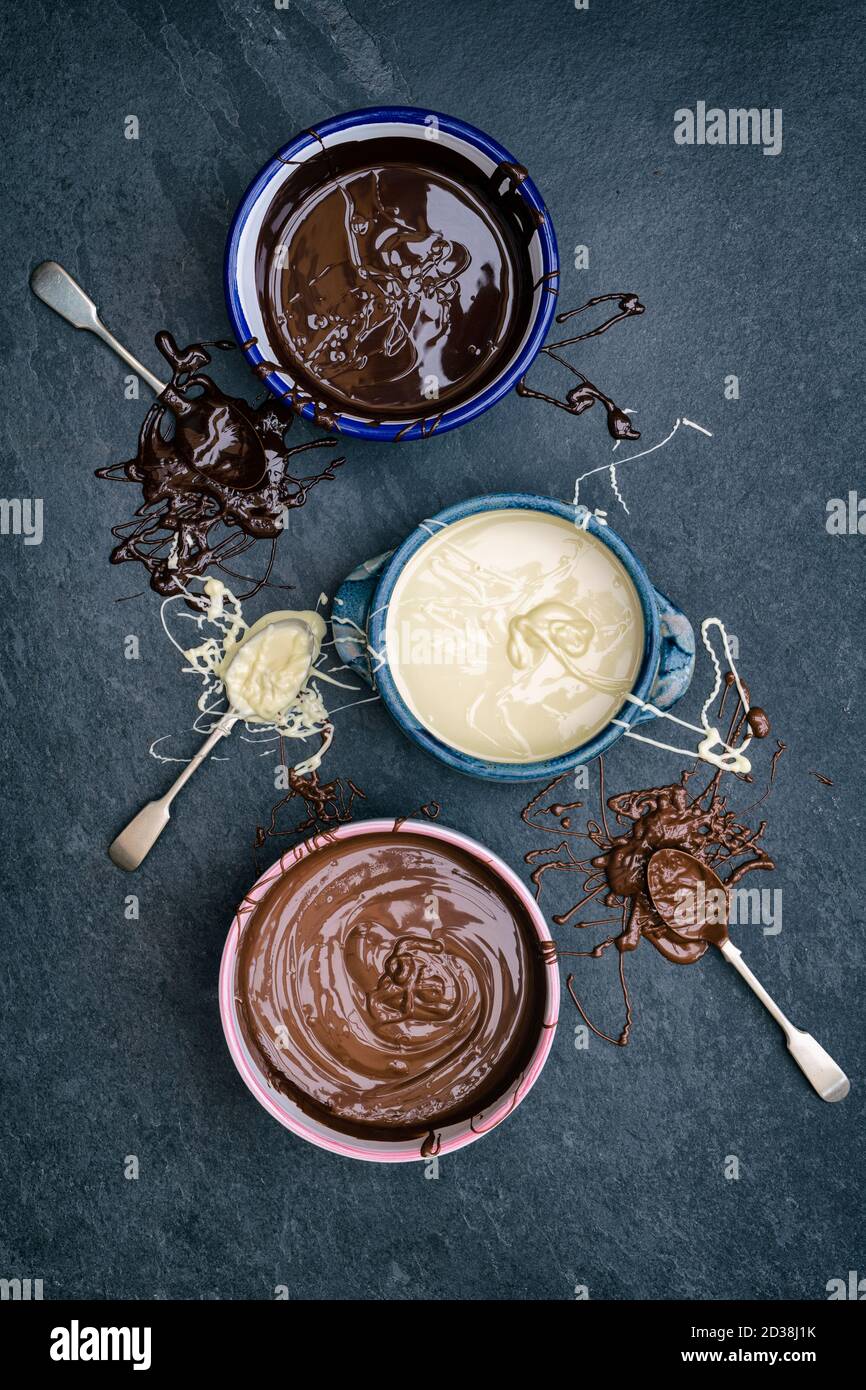 Three types of melted chocolate in bowls. Dark chocolate, milk chocolate, white chocolate Stock Photo
