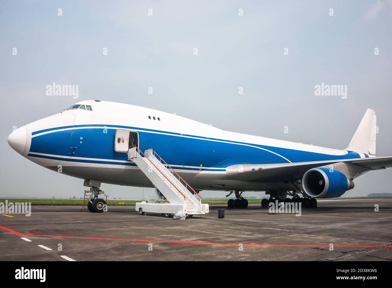Cargo wide body airplane with opened door and boarding ramp Stock Photo