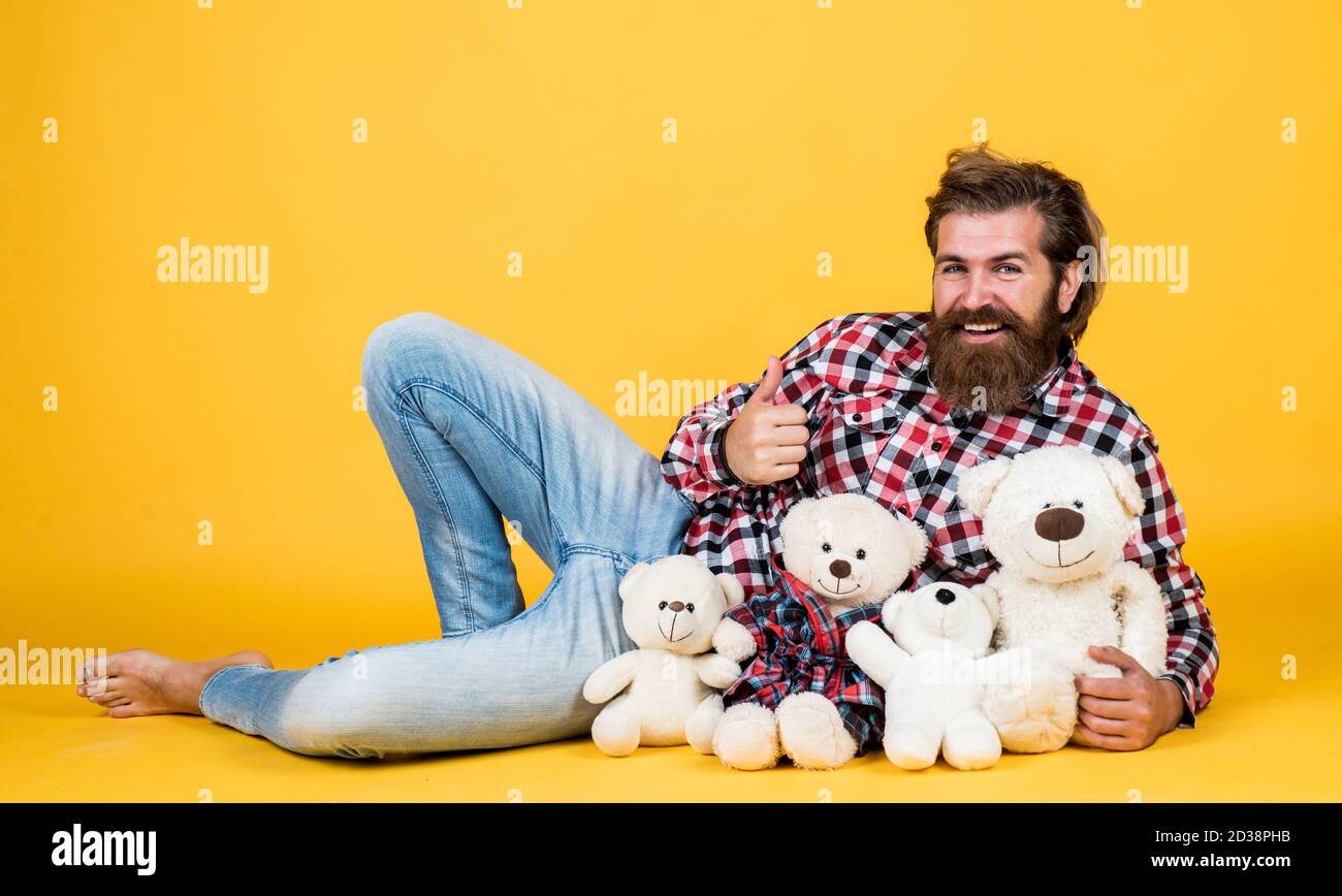 toy shop. Holiday celebration concept. Guy with happy face plays with soft toy. Childish mood concept. guy enjoy valentines day. best present ever. Valentines day gift for beloved. Stock Photo
