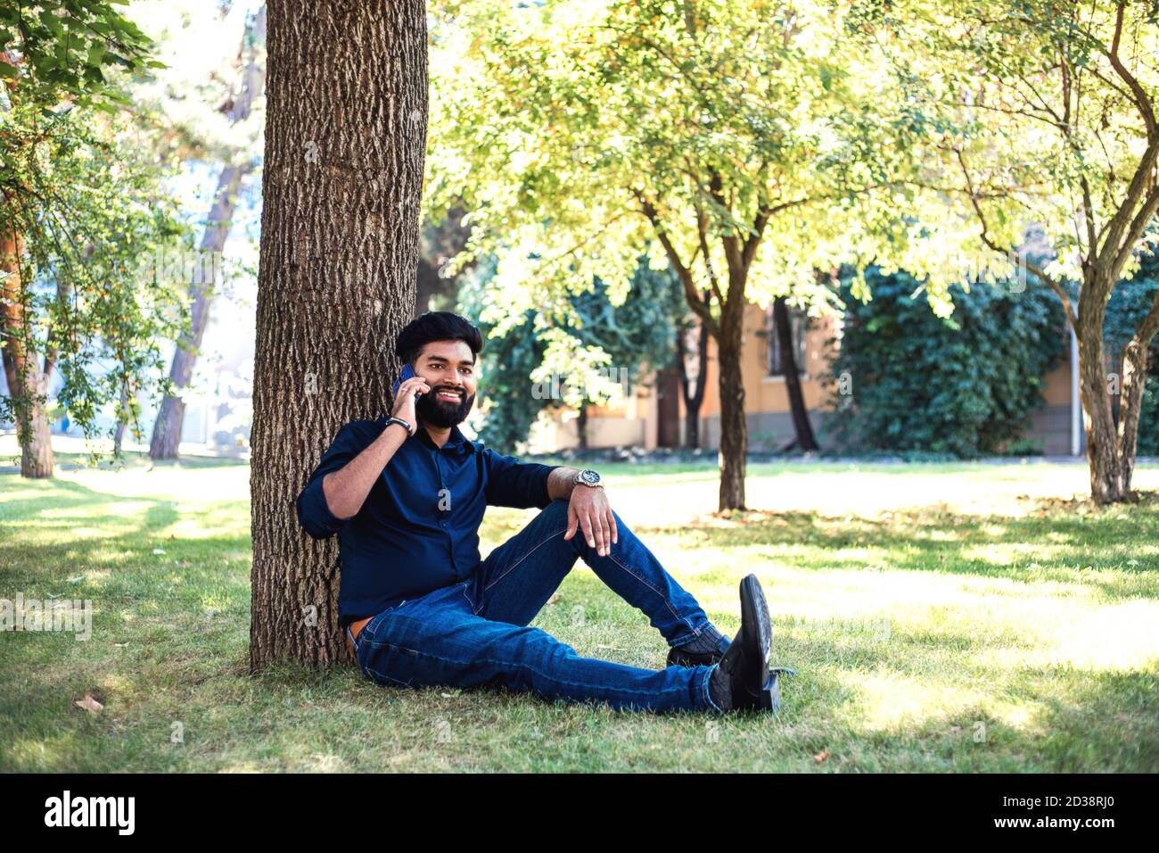 Young Indian man talking by phone in the park. Stock Photo